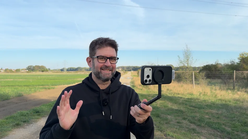 Christian Eggbauer outdoors, holding a smartphone filming setup.